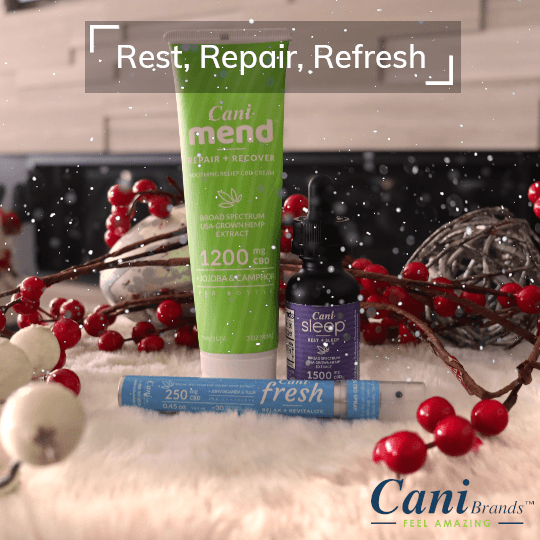 Alt=“CBD muscle relief cream, sleep oil and relaxation oral spray surrounded by Christmas decorations”