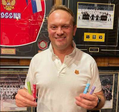 Alt=“Sergei Gonchar holding four oral spray supplements smiling”